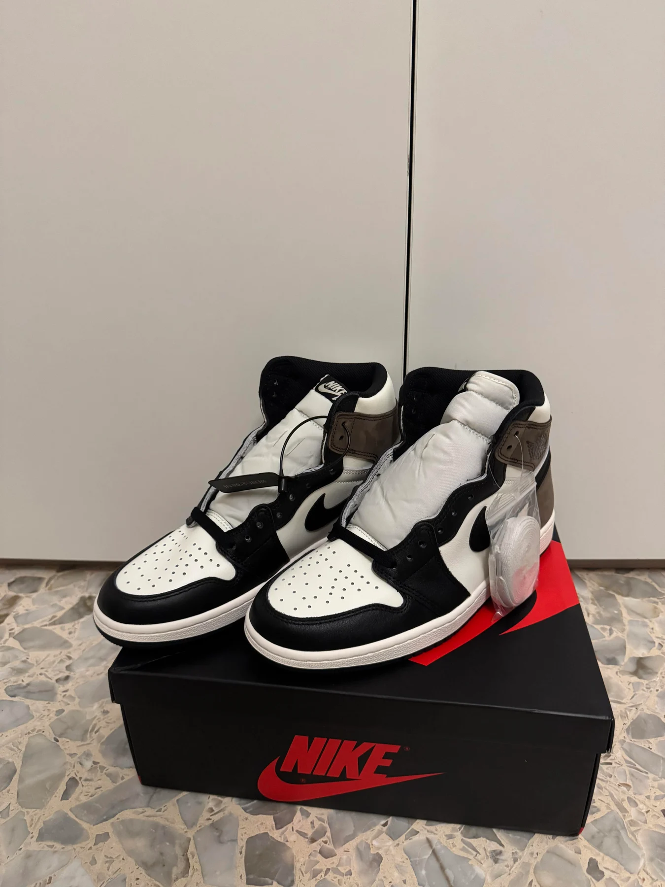 Black and white high-top sneakers on a Nike box.