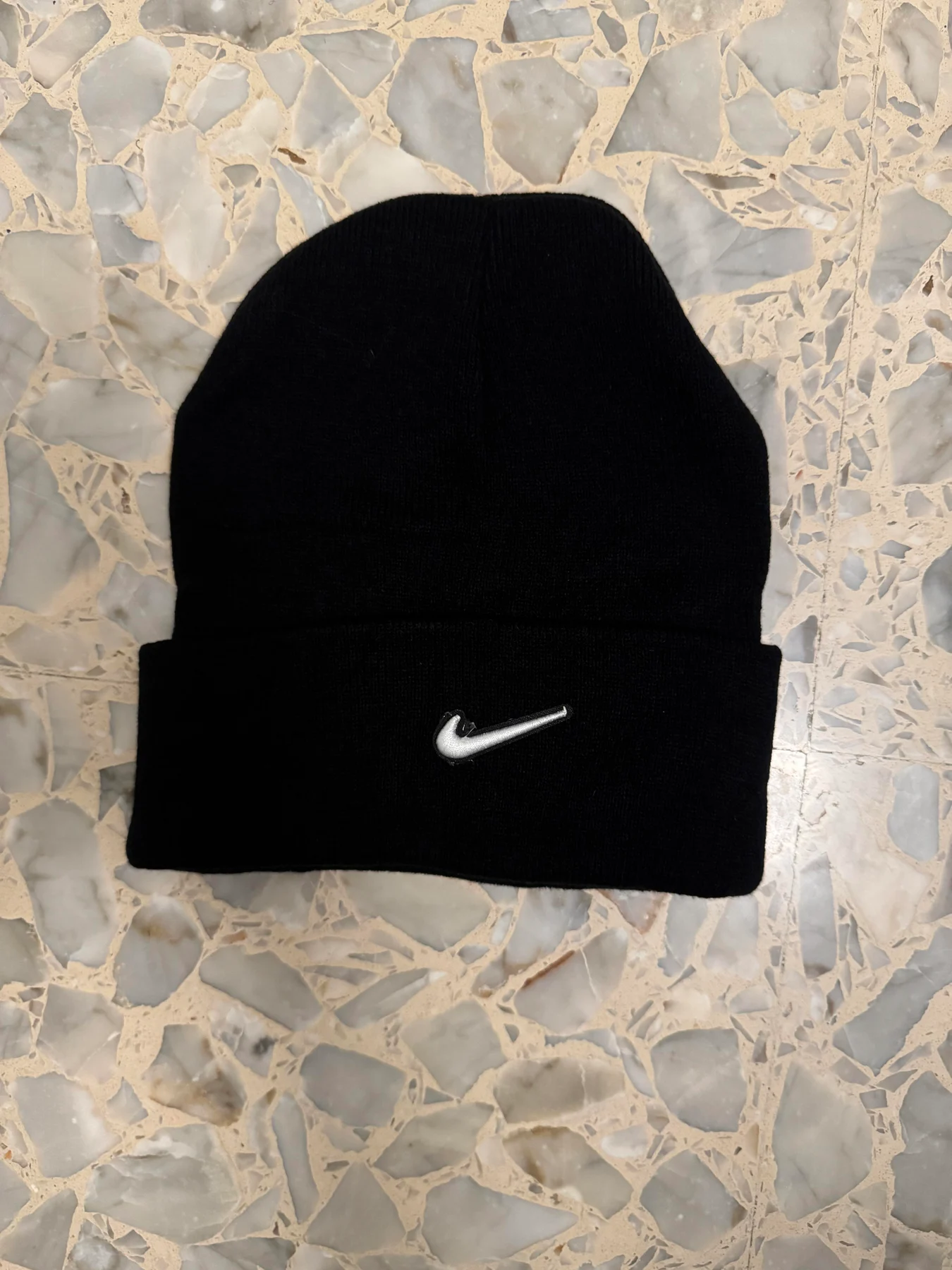 Black knit beanie with a white Nike logo.