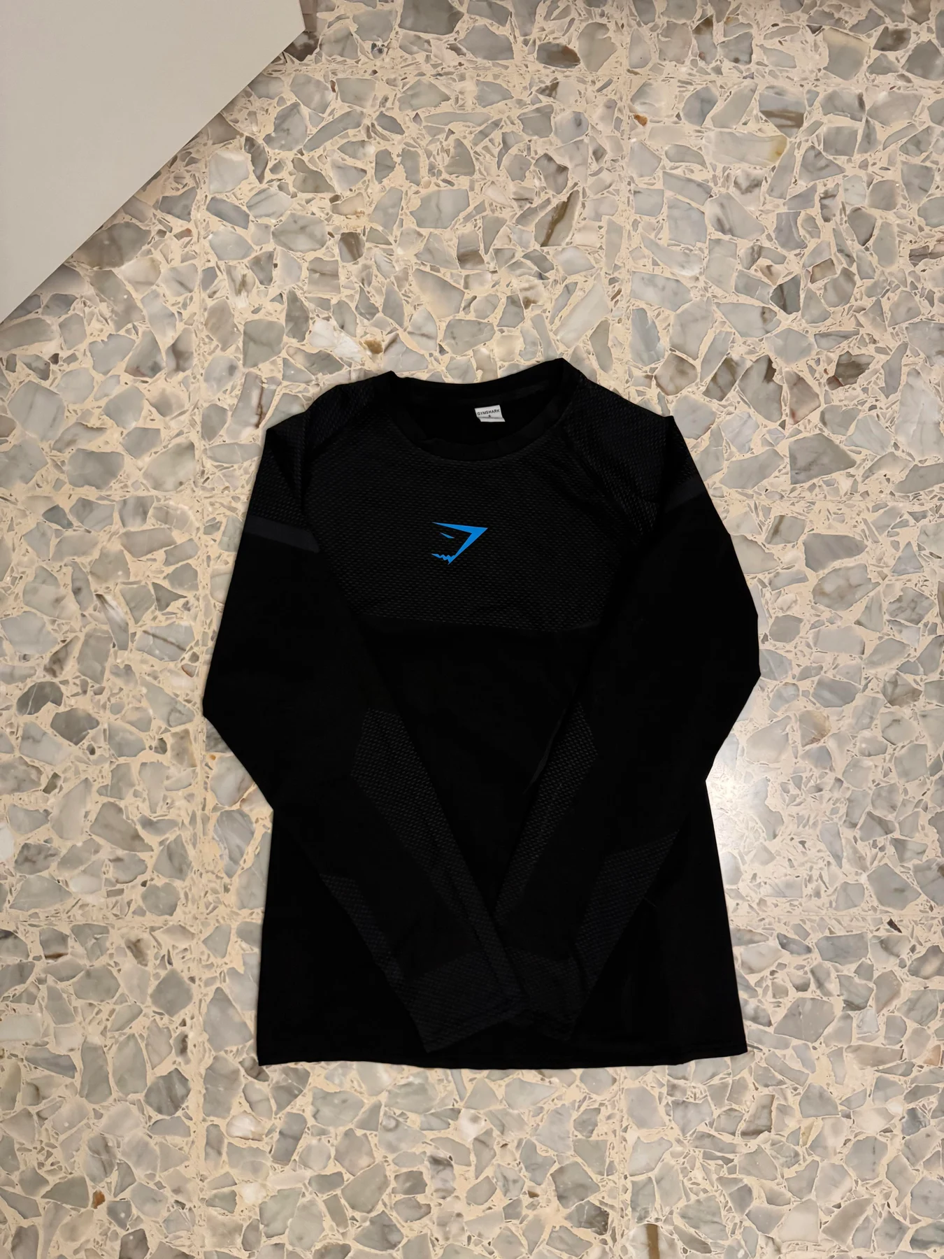 Black Gymshark top laid flat.