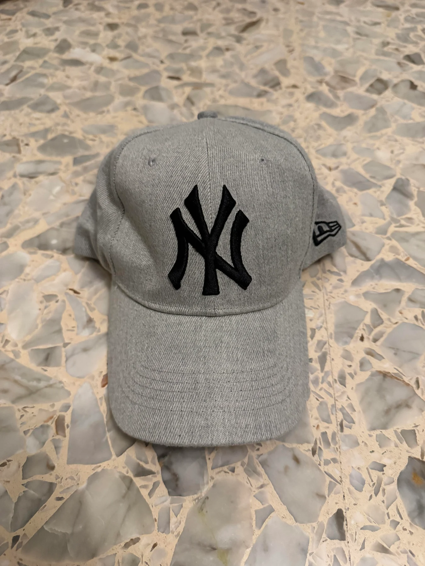 Front of a grey NY baseball cap.