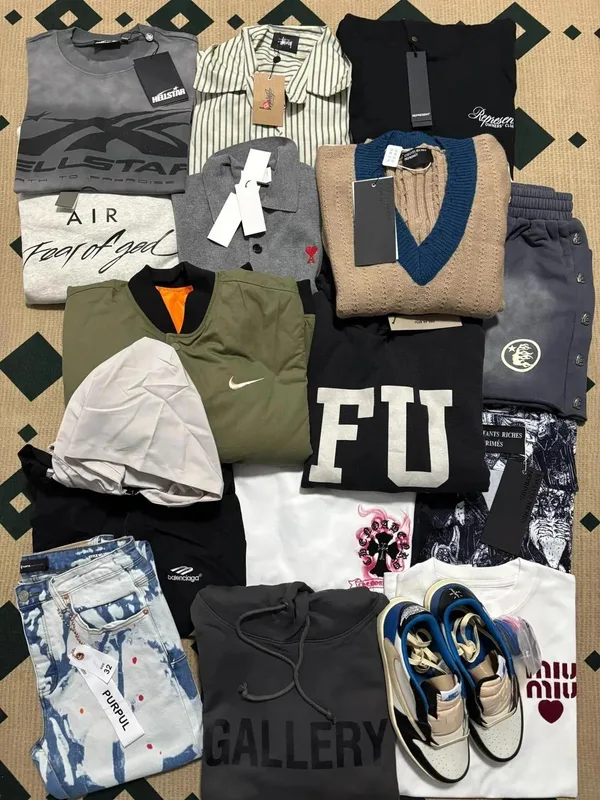 Clothing and sneakers arranged together on a patterned rug.