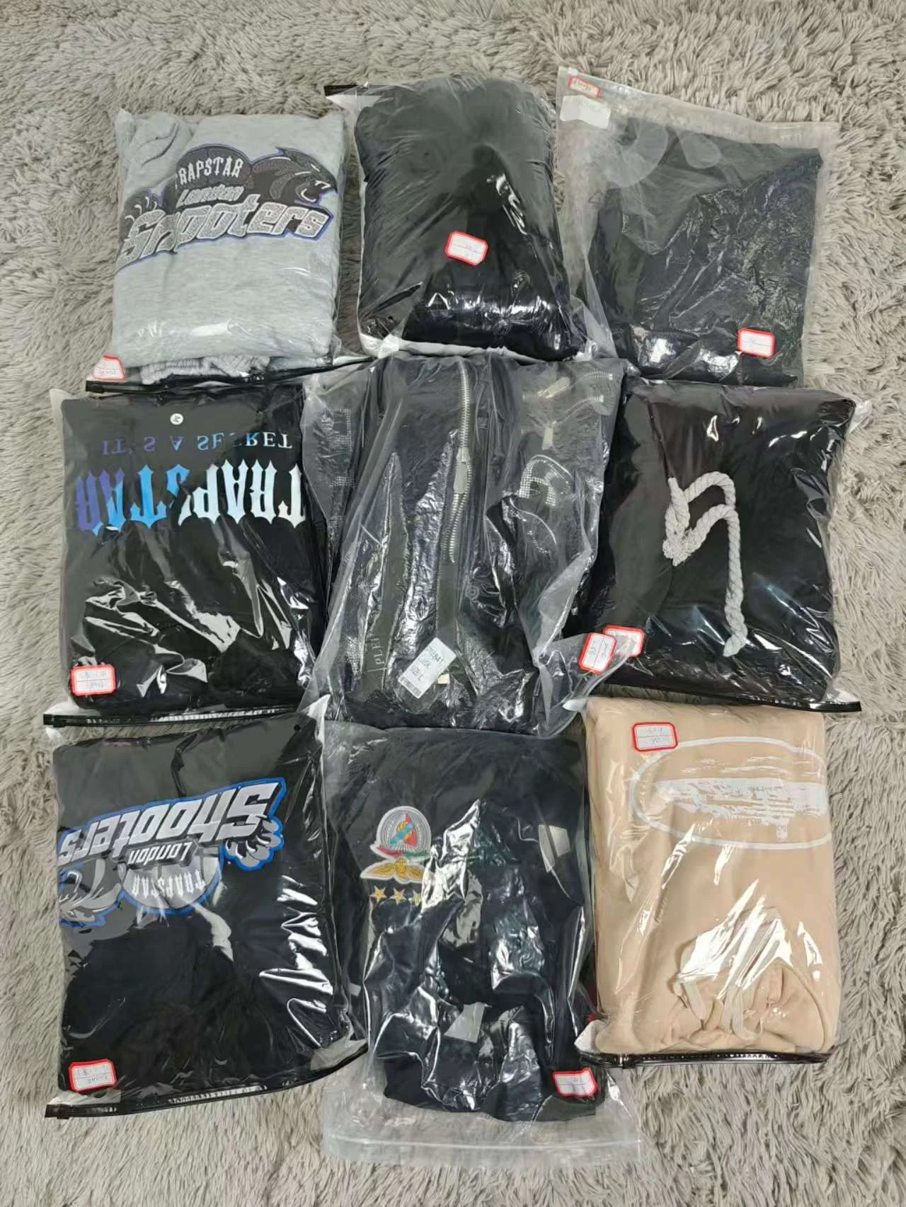 Selection of packaged clothing laid out on a rug.