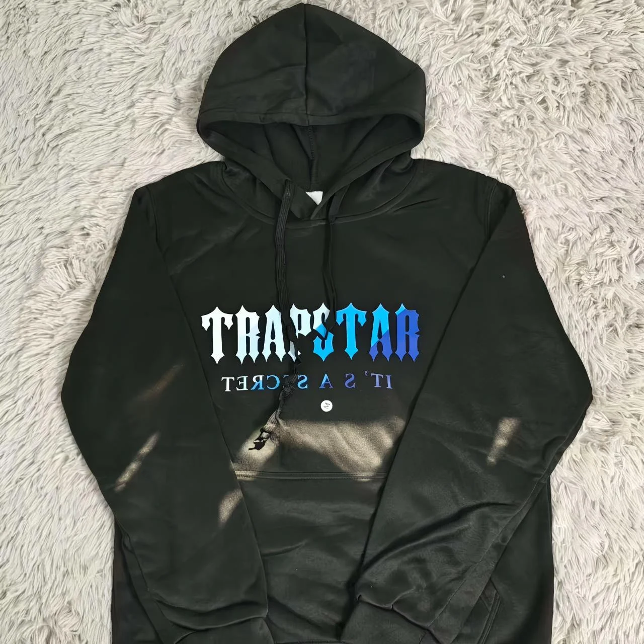 Dark Trapstar hoodie laid flat.
